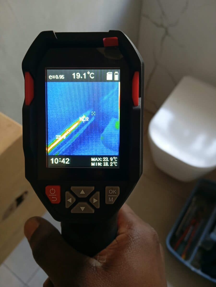 Thermal imaging camera mapping a hot water pipe behind a bathroom wall